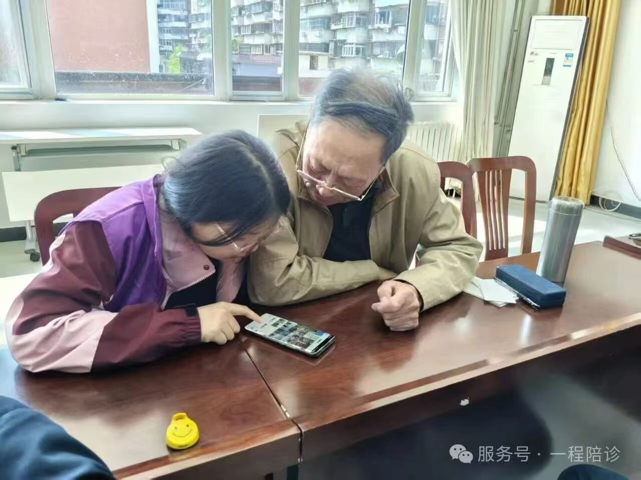 志愿者耐心帮助社区长者使用智能手机